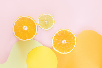 Halved lemons and oranges on vibrant colored wave backgrounds. Paper art style on photo. Concept of citrus, vitamin C, fruit.