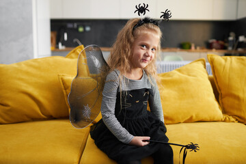 Funny child girl dressed in witch canival costume. Halloween holiday during quarantine time