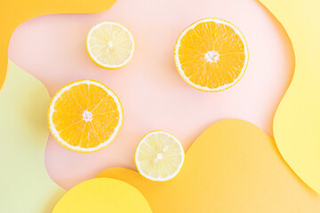 Halved lemons and oranges on vibrant colored wave backgrounds. Paper art style on photo. Concept of citrus, vitamin C, fruit.