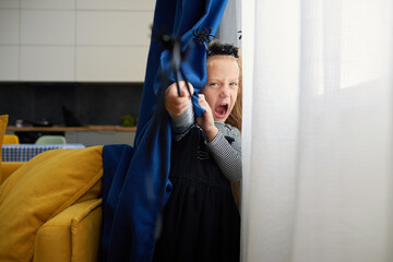 Funny child girl dressed in witch canival costume. Halloween holiday during quarantine time. Home patry