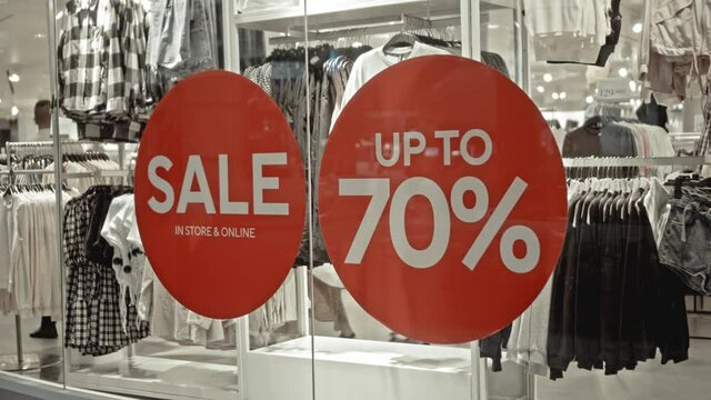 text on the red sticker on the glass of window in the store with the inscription sale up to 70% off