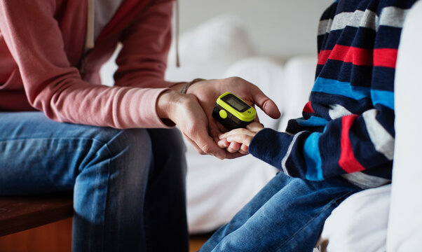 Mother measuring the oxygen with pulse oximeter to her kid