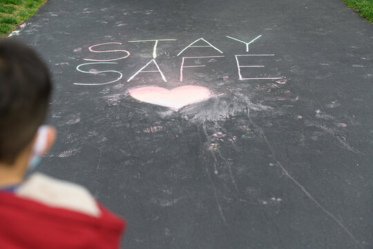Stay safe written in sidewalk chalk