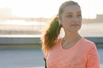 Mature woman listening to music during a run