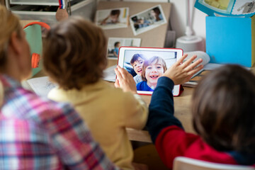 Mother and her kids doing video chat with their friends