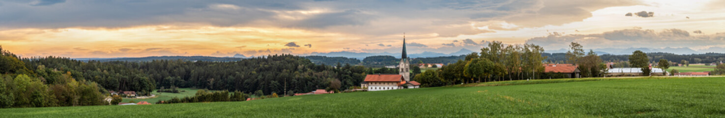 Kirche  vor Gebirge mit Wolken und Sonnenaufgang