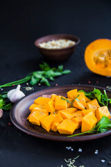 Beautifully chopped pumpkin slices, herbs, and ingredients for the dish. Creative atmospheric decoration