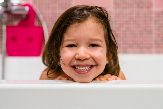Happy toddler in bathtub looking at camera