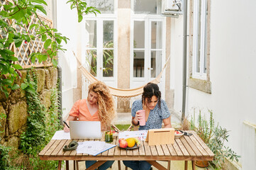 Friends working together at a table outside