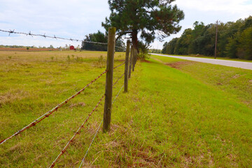Fence around farm land in the country low view