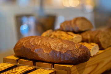 A cutting board with bread on self service table breakfast buffet in hotel catering