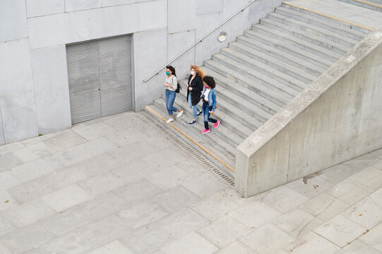 Women In Face Masks Walking Down Stairs Outside