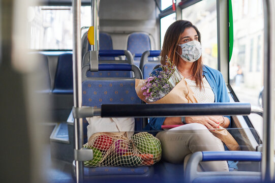 Woman In A Face Mask Riding On A City Bus