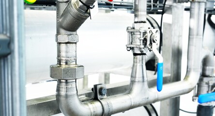 Large industrial water treatment and boiler room. Shiny steel metal pipes and switches