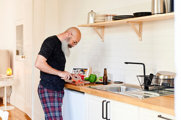 Mature man chopping vegetables for a meal
