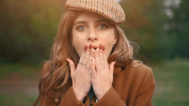 The shocked young pretty woman in a forest. The pretty female is looking at the camera and is surprised.