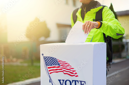 Woman voting at ballot box on american election day.
