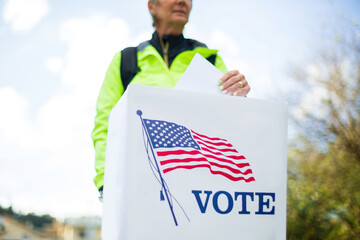 Woman voting at ballot box on american election day.