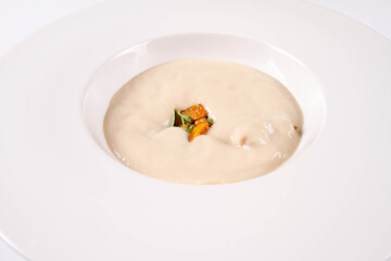 Sunroot cream soup served with some pumpkin and pine nuts 