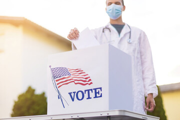 Doctor voting for president of america with face mask outside on sun.