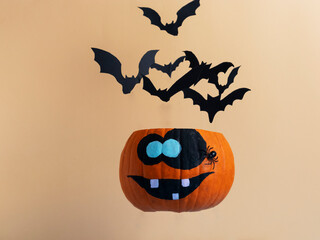 flying pumpkin with a funny face from which bats fly out, halloween card, copy space