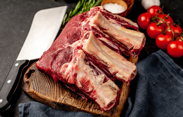 raw beef on the bone with spices on a stone background