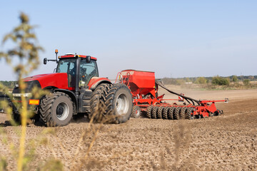 Fototapeta premium The tractor harvester working on the field