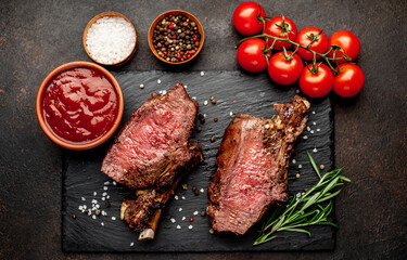 Baked beef on the bone with spices on a stone background
