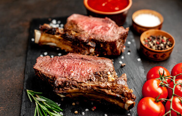 Baked beef on the bone with spices on a stone background