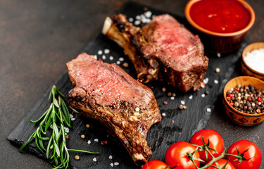 Baked beef on the bone with spices on a stone background