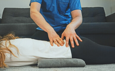 Therapist massaging woman's back at her house. Medical homecare.