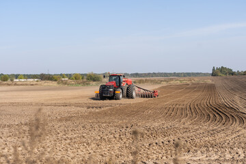 Obraz premium Tractor cultivating soil and preparing a field for planting