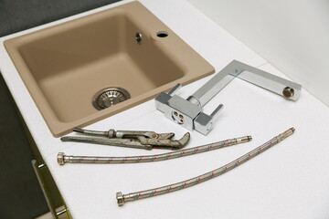 kitchen faucet replacement concept. mixer and hoses near the sink