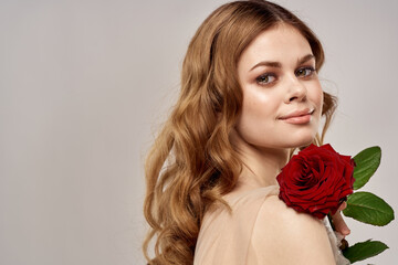 Red-haired woman with a rose in her hands on a light background emotions model portrait close-up