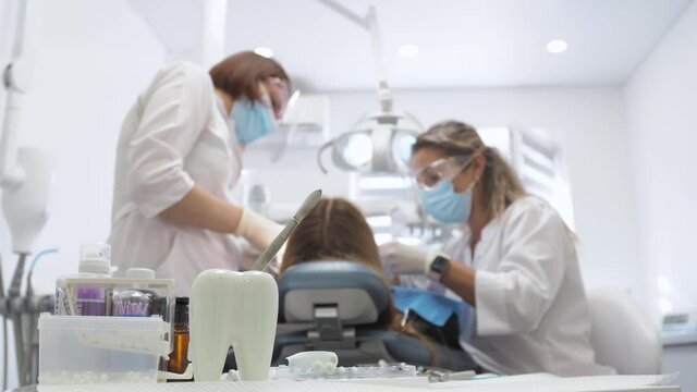 Young woman dentist. Reception at the orthodontist. Replacement of braces. Polishing. Gel bonding.