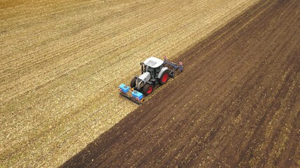 Traktor pflügt Feld nach der Ernte, Saatbettbereitung für eine Zwischenkultur im Winter,...
