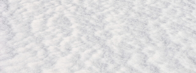 White snow surface background - top view of fresh snow texture on the ground, closeup, panorama,...