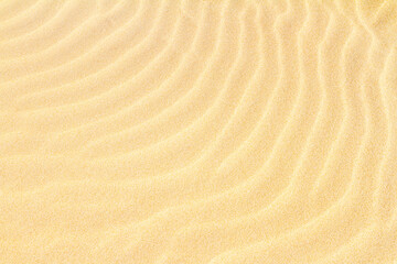 Rippled sand on the sea coast formed by wind and water, background, texture, pattern, banner