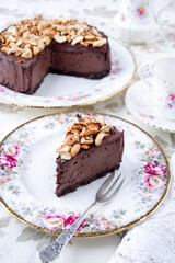 Fototapeta na wymiar Traditional chocolate pie with cashew nuts offered as close-up on a design bone China plate