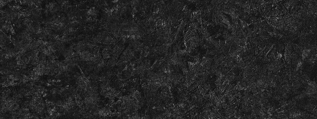 Abstract dark grey plastered textured grunge background in the form of a rough covered stucco wall, closeup