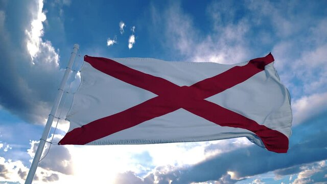 Alabama flag on a flagpole waving in the wind in the sky. State of Alabama in The United States of America