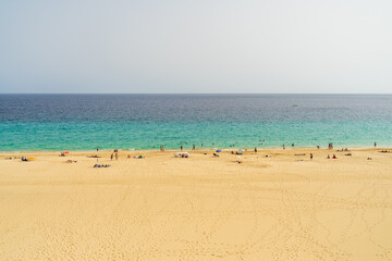 Fototapeta na wymiar Uncrowded but once popular sandy beach. Morro Jable. Fuerteventura, Canary Islands. Spain. Summer 2020. Consequences of the Tourism Industry Crisis Due to COVID-19.