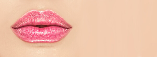 Beautiful young woman's lips closeup, on beige background. Plastic surgery, fillers, injection....