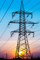 Electric power transmission lines. High voltage post. Industrial landscape. Electricity pylon at sunset sky on the background. Electric distribution station