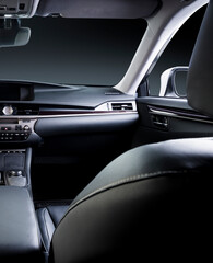 Dark luxury car Interior - steering wheel, shift lever and dashboard. Car inside. Beige comfortable seats, steering wheel, dashboard, climate control, speedometer, display.