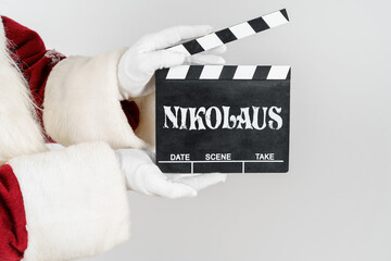 Santa Claus is holding a cracker in his hands - a numerator with the text - NIKOLAUS