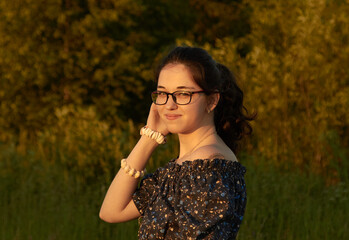 portrait of a shy girl against a background of trees