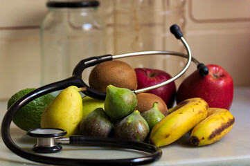 A stethoscope surrounds an assortment of healthy fruit