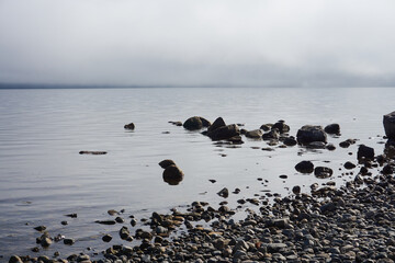 ROCAS Y PIEDRAS A LA ORILLA DEL LAGO NAHUEL HUAPI, CIELO NUBLADO CON NIEBLA, CIUDAD DE BARILOCHE, PROVINCIA DE RIO NEGRO, ARGENTINA, PAISAJES DE LA PATAGONIA