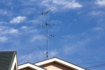 住宅の屋根の上のテレビのアンテナ